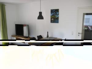 a living room with a table and chairs and a television at Apartment Haus Budinger by Interhome in Alf