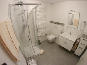 a bathroom with a shower and a toilet and a sink at Apartment Haus Budinger by Interhome in Alf +10 photos