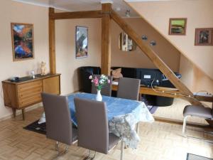 a dining room with a table with chairs and a desk at Apartment Haus Budinger by Interhome in Alf