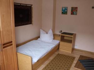 a small bedroom with a bed and a night stand at Apartment Haus Budinger by Interhome in Alf