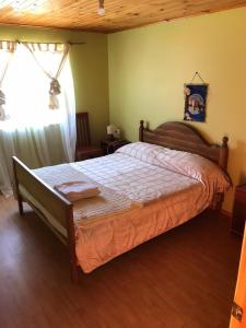 een slaapkamer met een bed en een raam bij Hostal Lucerna in Curanipe