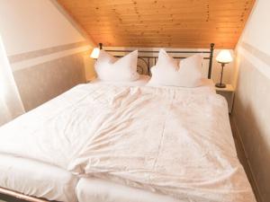 a bed with white sheets and pillows on it at Apartment Fewo Dirks 2 by Interhome in Hemfurth-Edersee