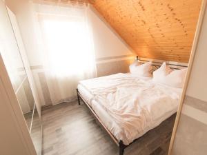 a bed in a room with a wooden ceiling at Apartment Fewo Dirks 2 by Interhome in Hemfurth-Edersee