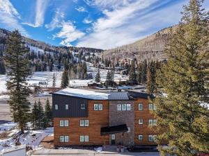 an apartment building in the mountains with snow on the ground at NEW 2BR w/ Ski Views, Bunk Room & Resort Access in Durango Mountain Resort