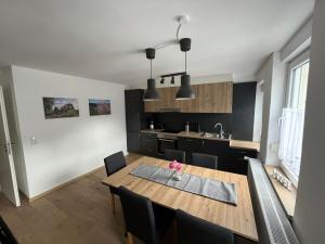 a kitchen with a wooden table and a dining room at Apartment Haus Budinger by Interhome in Alf
