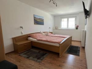 a bedroom with a bed with pink sheets and a window at Apartment Haus Budinger by Interhome in Alf