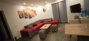 a living room with a red couch and a table at Suncani breg in Crni Vrh +2 photos