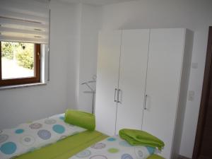 a bedroom with a bed and a white cabinet at Apartment FeWo Siebert by Interhome in Bad Brambach