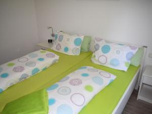two beds in a room with green sheets and pillows at Apartment FeWo Siebert by Interhome in Bad Brambach