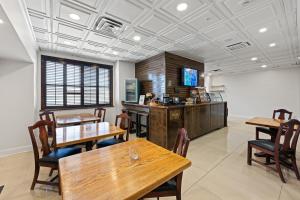 a restaurant with wooden tables and chairs and a tv at Hotel Phillips in Bartlesville