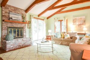 een woonkamer met een bank en een open haard bij The Perfect Beach Getaway in Orleans