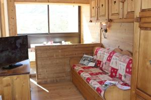 a living room with a couch and a tv at Vanoise Appartements VTI in Val Thorens