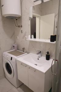 een badkamer met een wasmachine en een wastafel bij Splendid J&R apartman in Bijeljina
