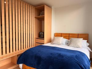 une chambre avec un lit avec une couverture bleue dans l'établissement Luminoso y Céntrico Loft con Balcón, à Sogamoso