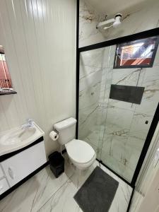 un bagno bianco con wc e doccia di Loft 02 na Praia Brava a Itajaí