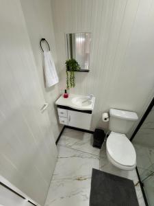 un bagno bianco con un water e un lavandino di Loft 02 na Praia Brava a Itajaí