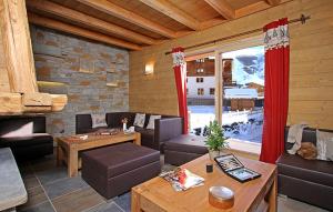 a living room filled with furniture and a large window at Odalys Chalet Prestige Lodge in Les Deux Alpes