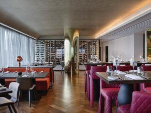 un restaurant avec des chaises et des tables rouges et des casiers à vin dans l'établissement SO/ Auckland, à Auckland