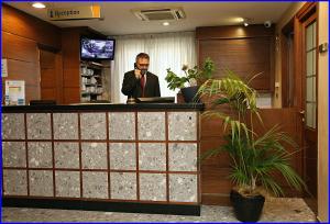 a man talking on a cell phone at a reception desk at Hotel Meeting in Ciampino