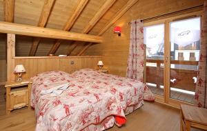 a bedroom with a bed and a large window at Odalys Chalet Prestige Lodge in Les Deux Alpes