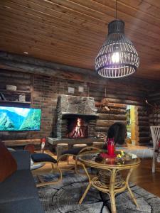 a living room with a table and a fireplace at Hillavilla in the shore of lake Inari in Inari