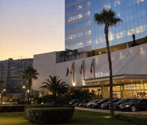 a building with a lot of cars parked in a parking lot at Hilton View Tower Residency Apartment Tanger Partial Sea View in Tangier