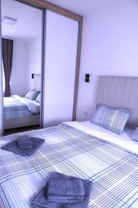 a bedroom with two beds with towels on them at Splendid J&R apartman in Bijeljina