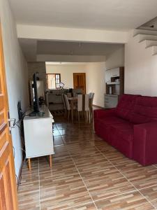 a living room with a red couch and a kitchen at Paraty Prime House in Paraty