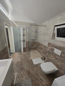 a bathroom with a toilet and a tv on the wall at Stylische Ferienwohnung 2 in Salzburg +12 photos