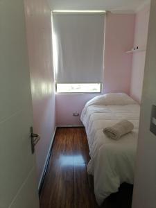 a small room with two beds and a window at departamento vacacional in Arica