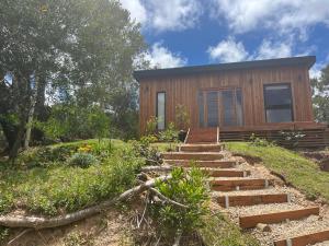 a wooden house with stairs in front of it at Mar de Fondo in La Pedrera