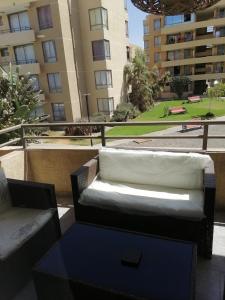a couch and a table on a balcony with buildings at departamento vacacional in Arica