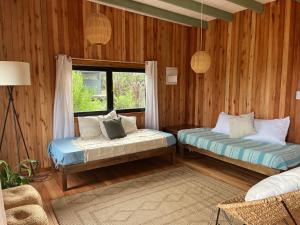 a bedroom with two beds and a window at Mar de Fondo in La Pedrera