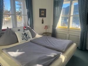 een bed in een kamer met ramen bij Villa Marktresidenz - Ihre Ferienwohnungen im Herzen von Berchtesgaden in Berchtesgaden