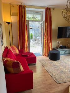 een woonkamer met een rode bank en een tv bij Villa Marktresidenz - Ihre Ferienwohnungen im Herzen von Berchtesgaden in Berchtesgaden +17 foto's