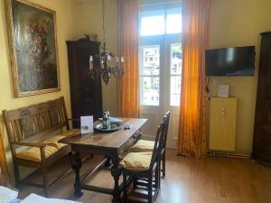 a dining room with a table and chairs and a television at Villa Marktresidenz - Ihre Ferienwohnungen im Herzen von Berchtesgaden in Berchtesgaden +16 photos