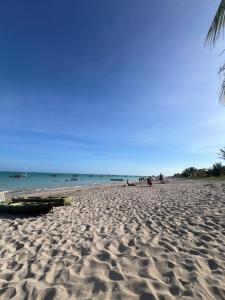 een strand met mensen en de oceaan op de achtergrond bij Flats Brisa Antunes in Maragogi