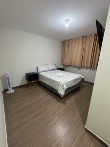 a bedroom with a bed and a wooden floor at Moderno Mn Depa en San Bartolo in San Bartolo