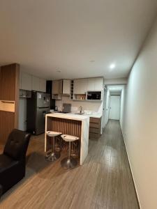 a kitchen with a counter and stools in a room at Moderno Mn Depa en San Bartolo in San Bartolo
