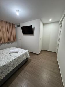 a bedroom with a bed and a flat screen tv at Moderno Mn Depa en San Bartolo in San Bartolo