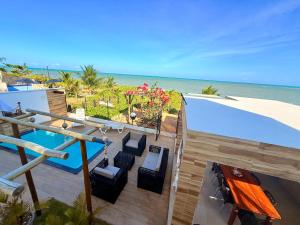 a balcony with chairs and the ocean in the background at Roraimar Prime Maragogi - Beira Mar in Maragogi