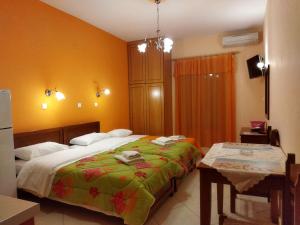 una camera da letto con un letto grande e un tavolo di Avra Apartments a Leonidion (Leonidio)