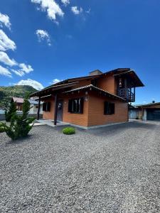a house with a gravel driveway in front of it at Casa de Temporada Vó Laura in Urubici