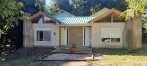 a small house with a porch and a door at La esmeralda verde in Villa Ventana