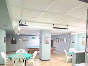 una camera con tavolo, sedie e tavolo da biliardo di Moda Apartments Cimaboschi a Sestriere