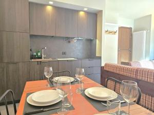 tavolo da pranzo con bicchieri da vino di Moda Apartments Cimaboschi a Sestriere