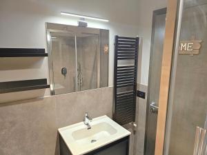 un bagno con lavandino e doccia di Moda Apartments Cimaboschi a Sestriere