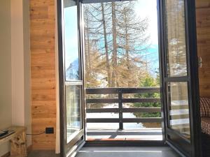 a room with a large window with a view at Moda Apartments Cimaboschi in Sestriere
