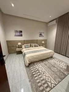 une chambre avec un grand lit et un tapis dans l'établissement شقة Vip عائلية وصول ذاتي, à Hafr Al Baten