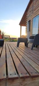a wooden deck with two benches on a house at Cabaña A&A in Sierra de la Ventana